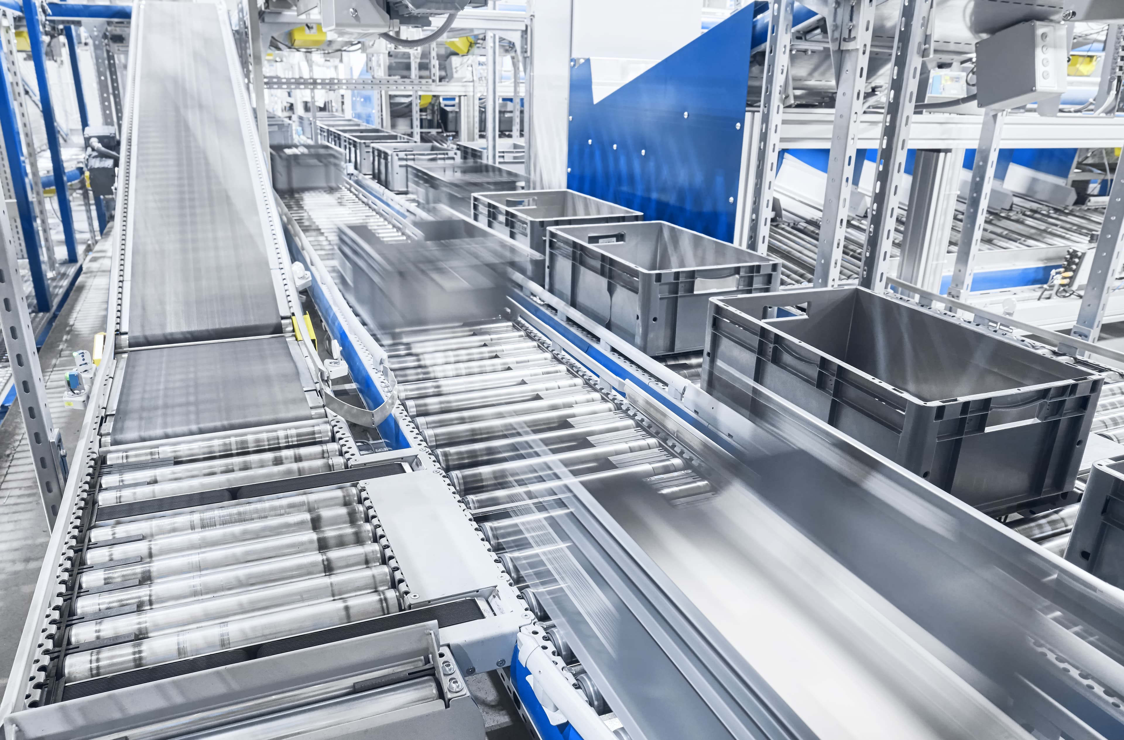 Grey returnable containers on automated conveyor system